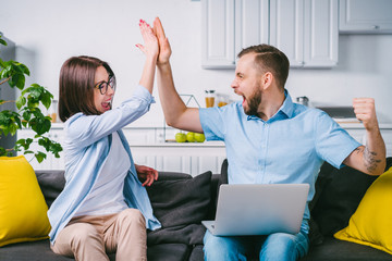 Young couple celebrating money win after betting online at bookmaker's website