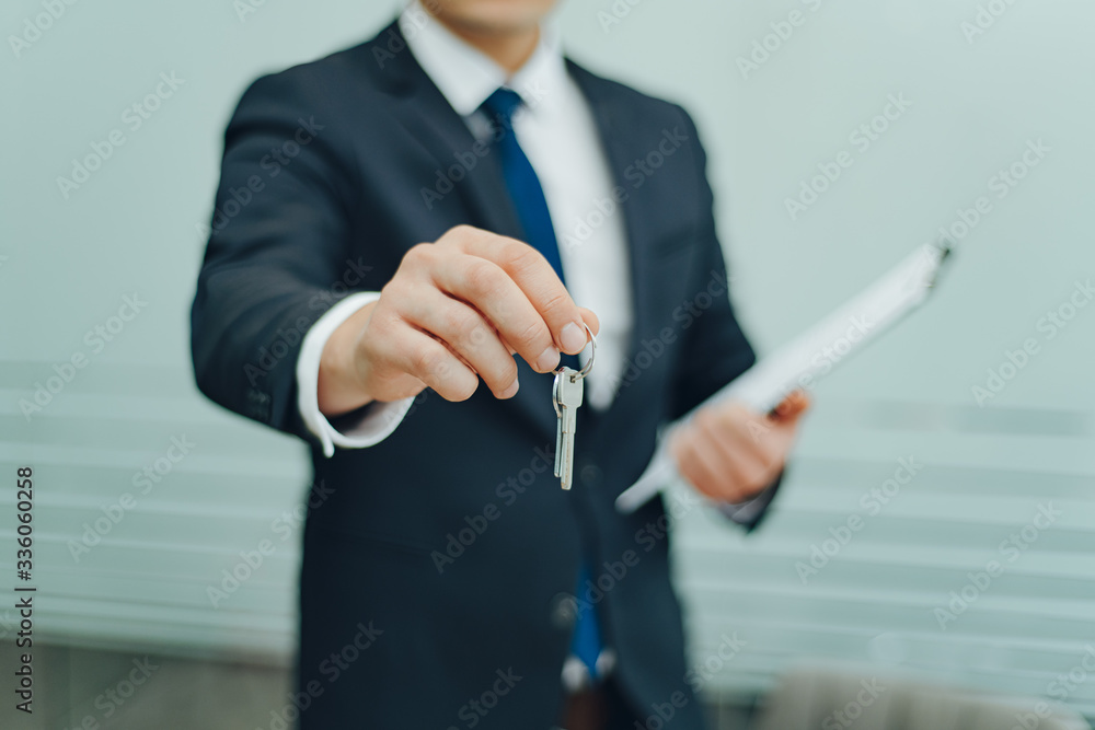 Real estate agent holding keys and contract agreement. In office. Concept for real estate, sale, moving home, renting property. Selective focus - obrazy, fototapety, plakaty 
