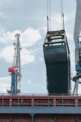 in port loading scrap metal on a barge