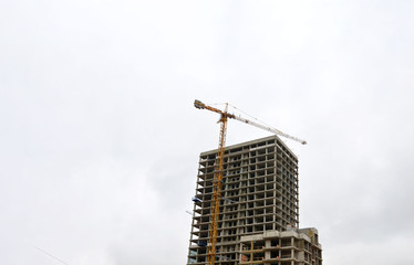 Tower cranes constructing a new building at construction site.