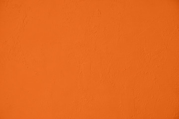 Saturated orange colored low contrast Concrete textured background with roughness and irregularities. 2020, 2021 color trend.