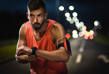 Wall Mural - Man running through the city street at night.