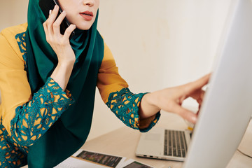 Wall Mural - cropped image of muslim business lady in traditional clothes pointing at computer screen and talking