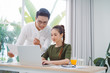 © makistock - Two young business colleagues working with laptop at office