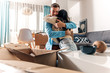 © Zoran Zeremski - Smiling young couple move into a new home sitting on floor and unpacking boxes of their belongings.