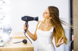 © Тарас Нагирняк - Young beautiful girl dries long hair dryer in front of mirror.