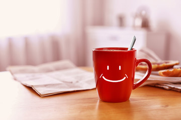 Canvas Print - Aromatic coffee in cup with happy face on wooden table indoors, space for text. Good morning