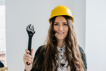 young girl in a helmet holding a wrench