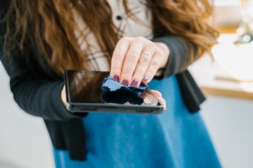 Wall Mural - woman hands cleaning a tablet with a napkin