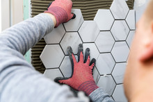 Tiling - Man Laying Marble Texture Hexagon Tiles On The Wall
