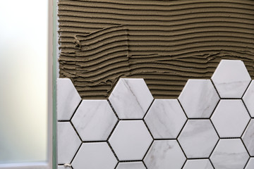 tiling - laying white marble texture hexagon tiles on the wall