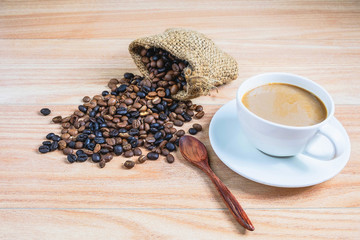 Coffee cups and roasted coffee beans on a wooden table