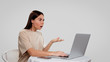© South House Studio - woman shows her emotions in a complaint, she put her palm in monitor and open her mouth, isolated.