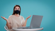© South House Studio - woman put her hands a sight in a surprise, she use her computer and wear black medical mask