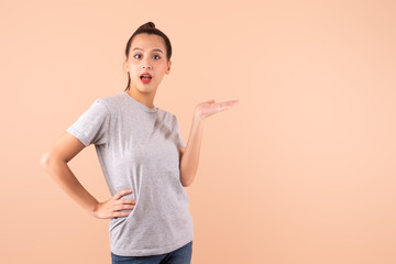 Young beautiful Asian woman girl open hand to present product over pink background with copy space