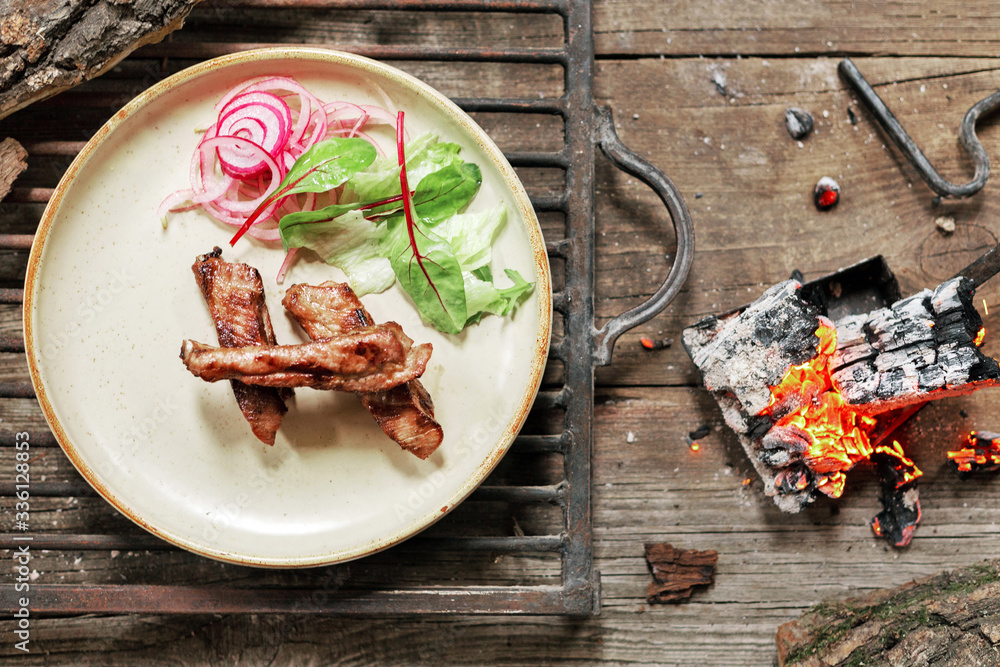 lunch grilled meat pork on vintage wood table in rustic style. Coals in ...