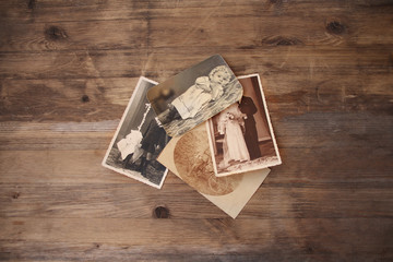 old vintage monochrome photographs in sepia color are scattered on a wooden table, the concept of genealogy, the memory of ancestors, family ties, memories of childhood