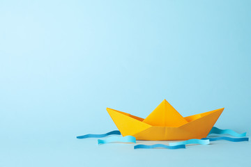 Paper boat and waves on blue background, space for text