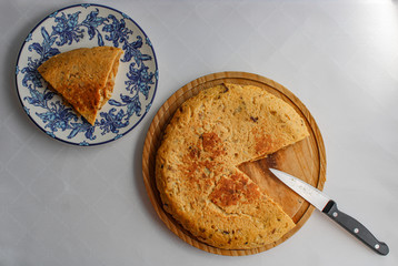 Poster - Spanish potato omelette next to a serving piece. Top View. Whole potato omelette on top of a wooden board. 