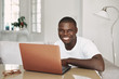 © SHOTPRIME STUDIO - A man of African appearance at home in front of a laptop relaxing