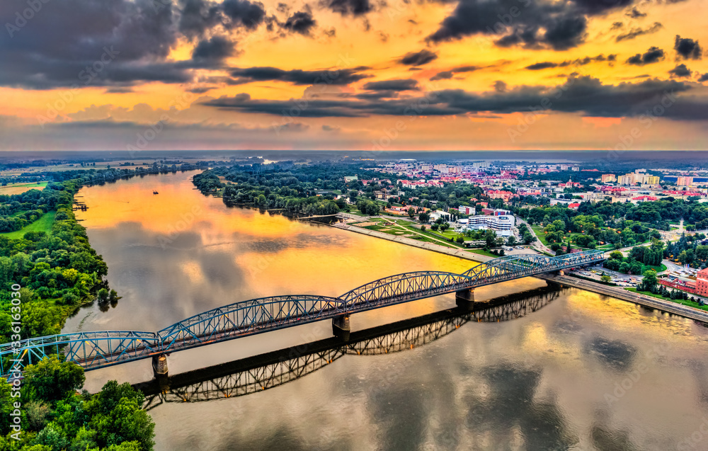 Jozef Pilsudski Bridge across the Vistula River at sunset in Torun, Poland - obrazy, fototapety, plakaty 