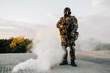 Military man in a respirator with a military machine gun in his hands standing guard