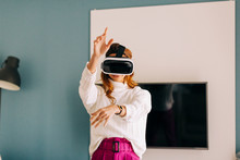 Happy Young Woman Wearing VR Glasses At Home