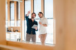 © Westend61 - Two businessmen with tablet talking at the window in wooden open-plan office