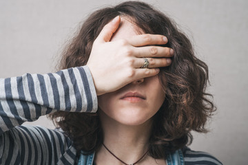 Wall Mural - girl covering her eyes with her hands