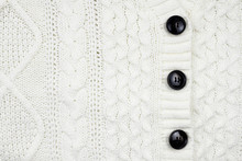 Closeup Of White Knitted Textile Detail Of Cardigan For Background