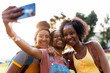 © Santi Nunez/Stocksy - Three smiling girl friends making selfie with smart phone.