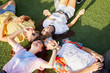 © ALTO IMAGES/Stocksy - Teenagers relaxing on the grass field