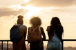 © Santi Nunez/Stocksy - Rear view of three african girls together holding the railing, l