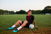 Football Player Sitting In The Field.