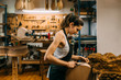 © MyMicrostock/Stocksy - Young Woman Luthier working in handcrafted spanish guitar