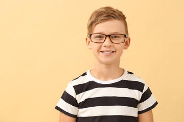 Wall Mural - Cute little boy with eyeglasses on color background