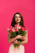 © LIGHTFIELD STUDIOS - attractive girl holding bouquet of spring tulip flowers isolated on pink