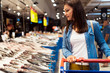 © Santi Nunez/Stocksy - Beautiful woman buying fish in a fish shop