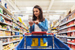 © Santi Nunez/Stocksy - Beautiful woman buying food in a supermarket