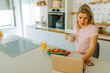© Nebojsa - Close photo of worried blonde woman reading news about COVID19 while having breakfast. Blond woman is using laptop while drinking coffee in the morning.