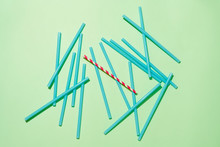 Paper Straw Among With Pile Plastic Straws On Green Background