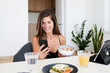 © Ivan Gener/Stocksy - Healthy summer breakfast using smartphone.
