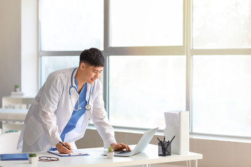 Wall Mural - Male Asian doctor working in clinic