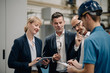 © Westend61 - Business people and worker talking in a factory