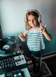 © Westend61 - Portrait of little DJane with headphones showing Rock And Roll Sign