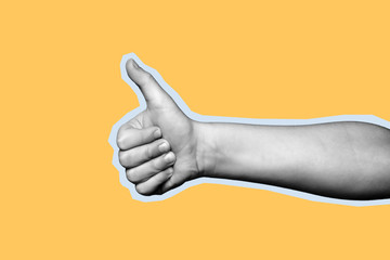 Wall Mural - Child hand shows thumb up on yellow background. Paper cut style.