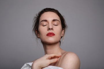 Beauty portrait of young woman with red lips and closed eyes.. Close-up portrait.