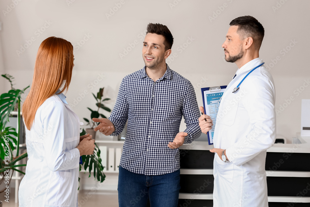 Doctors with patient in hall of clinic