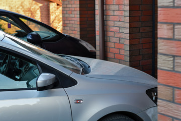 Wall Mural - Front part of a car parked in front of the garage door. Selective focus.