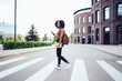 © BullRun - Serious young African American female crossing street in city
